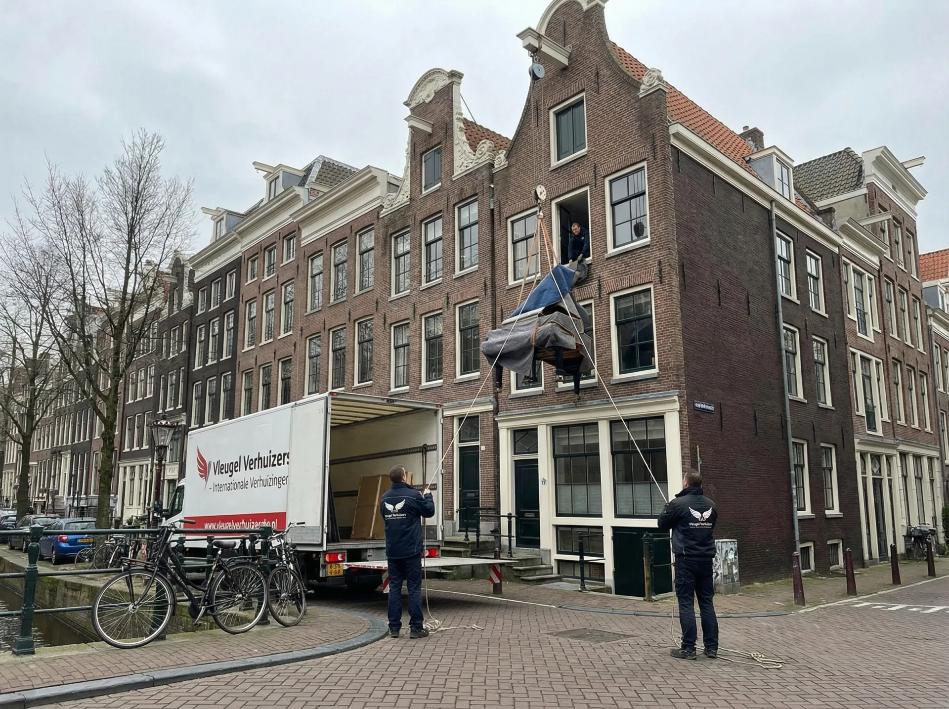 Professionele verhuizers tillen meubels bij particuliere verhuizing